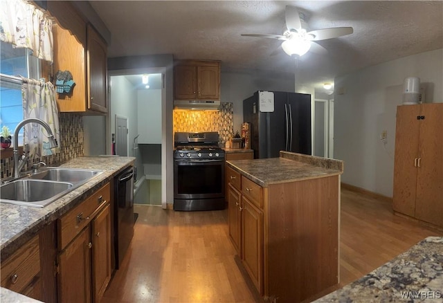 9357 Steffi Dr, Evans, NY 14006 - kitchen featuring range with gas stovetop, a sink, freestanding refrigerator, black dishwasher, and light wood-type flooring