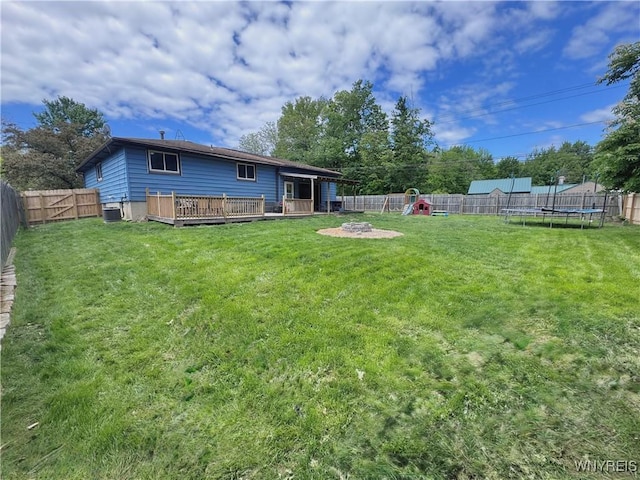 9357 Steffi Dr, Evans, NY 14006 - rear view of house featuring a trampoline, a wooden deck, a playground, central AC unit, and a fire pit