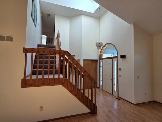 70 Crestway Ln, Greece, NY 14612 - entrance foyer with a skylight, stairway, wood finished floors, baseboards, and a chandelier