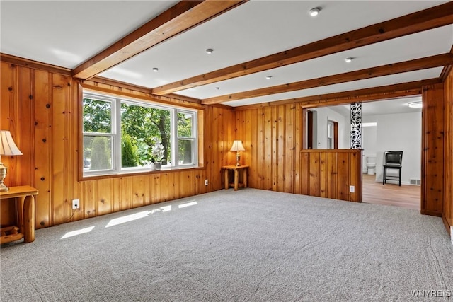 5302 William St, Lancaster, NY 14086 - unfurnished living room featuring carpet floors, beam ceiling, and wooden walls