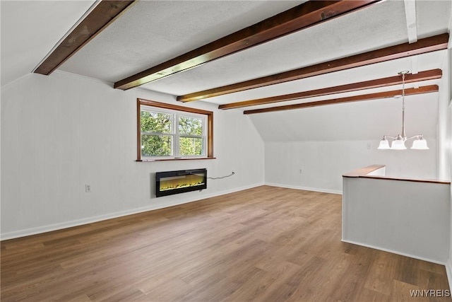 5302 William St, Lancaster, NY 14086 - unfurnished living room featuring a glass covered fireplace, baseboards, wood finished floors, and a chandelier
