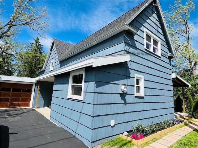 5302 William St, Lancaster, NY 14086 - view of home's exterior with roof with shingles, asphalt driveway, and a garage