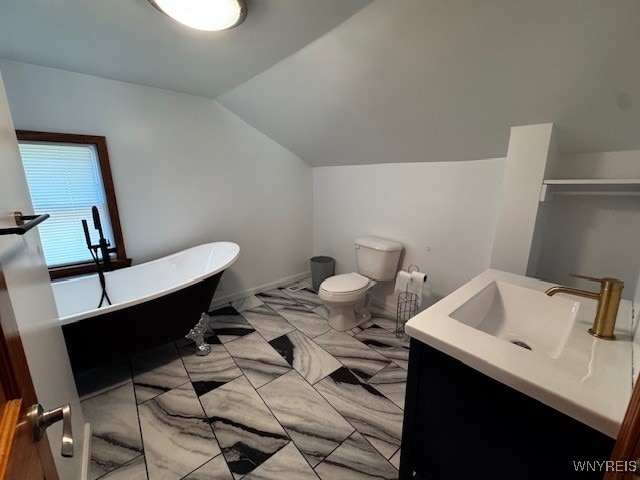 21 Maple St, Evans, NY 14006 - bathroom with a freestanding bath, vanity, vaulted ceiling, toilet, and baseboards