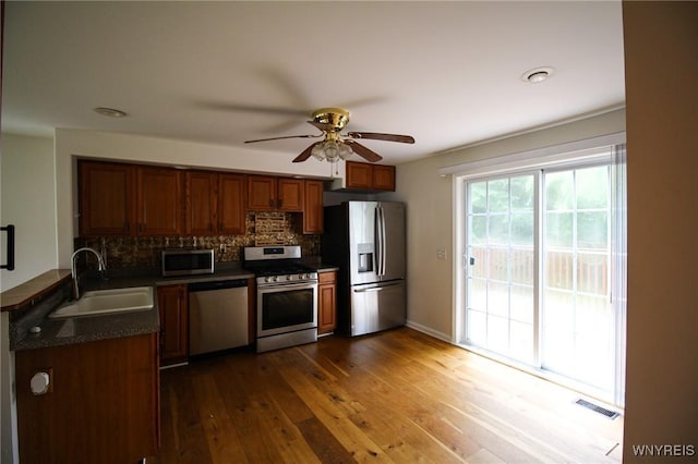 21 Maple St, Evans, NY 14006 - kitchen with appliances with stainless steel finishes, dark countertops, a ceiling fan, tasteful backsplash, and brown cabinets