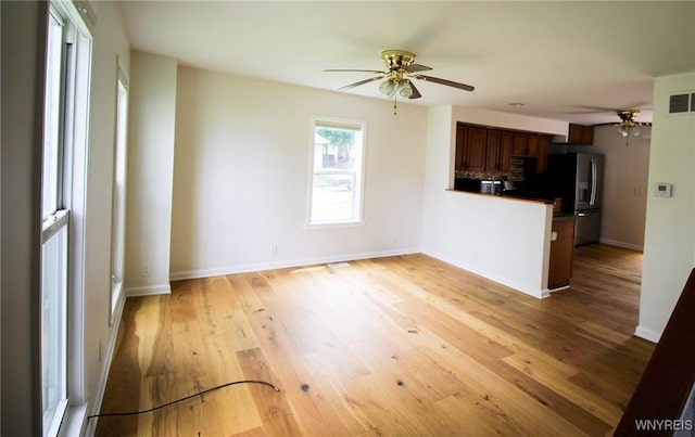 21 Maple St, Evans, NY 14006 - kitchen featuring a ceiling fan, stainless steel refrigerator with ice dispenser, a peninsula, dark countertops, and light wood-type flooring