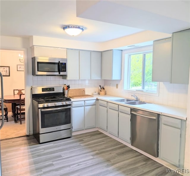 343 Carrollwood Dr, Porter, NY 14174 - kitchen with stainless steel appliances, a sink, decorative backsplash, and light countertops