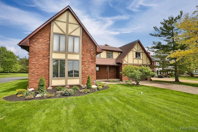 2227 W River Rd, Grand Island, NY 14072 - tudor home featuring a front lawn, brick siding, and stucco siding