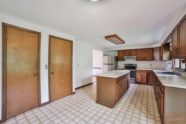 2227 W River Rd, Grand Island, NY 14072 - kitchen featuring stainless steel appliances, a sink, range hood, a kitchen island, and light countertops