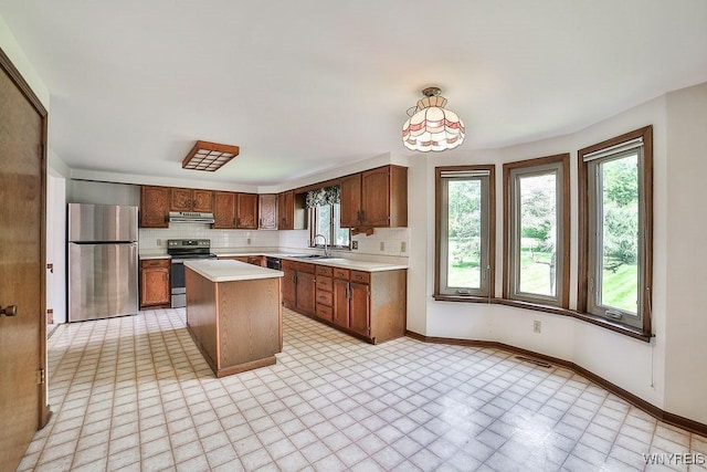 2227 W River Rd, Grand Island, NY 14072 - kitchen featuring appliances with stainless steel finishes, ventilation hood, light countertops, and healthy amount of natural light