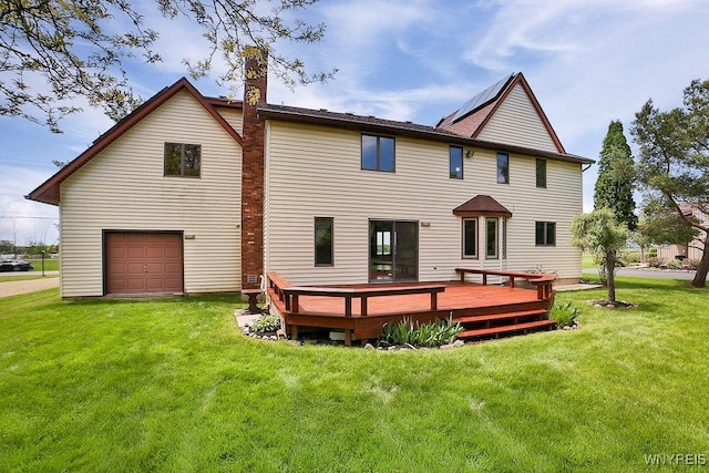 2227 W River Rd, Grand Island, NY 14072 - back of house featuring a deck, a lawn, a chimney, and an attached garage