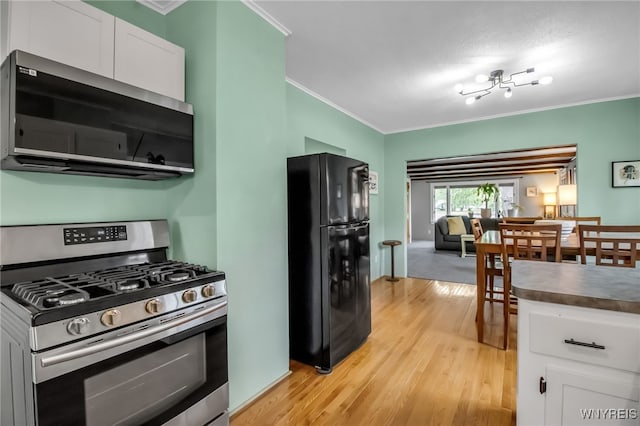 5870 Goodrich Rd, Clarence, NY 14032 - kitchen with gas range, freestanding refrigerator, crown molding, white cabinetry, and light wood-type flooring