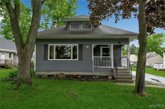 5870 Goodrich Rd, Clarence, NY 14032 - bungalow featuring a chimney, covered porch, roof with shingles, and a front lawn