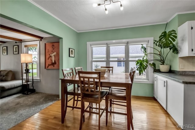 5870 Goodrich Rd, Clarence, NY 14032 - dining room featuring healthy amount of natural light, light wood finished floors, crown molding, and a textured ceiling