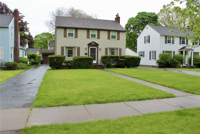 311 N Rogers Pkwy W, Irondequoit, NY 14617 - colonial-style house featuring a front yard and a chimney