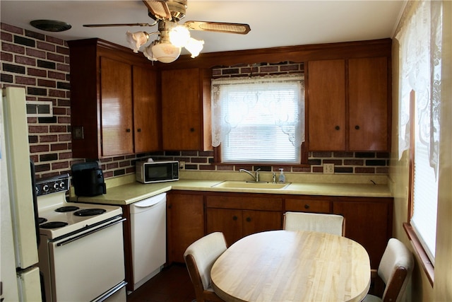 311 N Rogers Pkwy W, Irondequoit, NY 14617 - kitchen featuring white appliances, a sink, light countertops, brown cabinets, and decorative backsplash