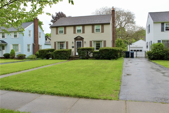 311 N Rogers Pkwy W, Irondequoit, NY 14617 - colonial-style house with an outbuilding, a chimney, a front lawn, and a garage