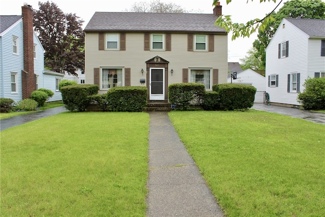 311 N Rogers Pkwy W, Irondequoit, NY 14617 - colonial-style house featuring a chimney, a front yard, and entry steps