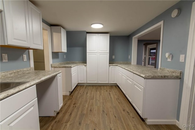 118 Leray St, Le Ray, NY 13612 - kitchen with light wood-style floors, white cabinetry, and light stone countertops