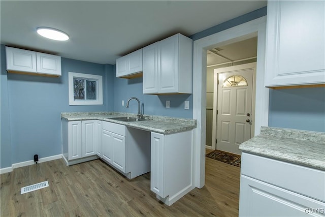 118 Leray St, Le Ray, NY 13612 - kitchen featuring a sink, light wood-type flooring, baseboards, and white cabinetry