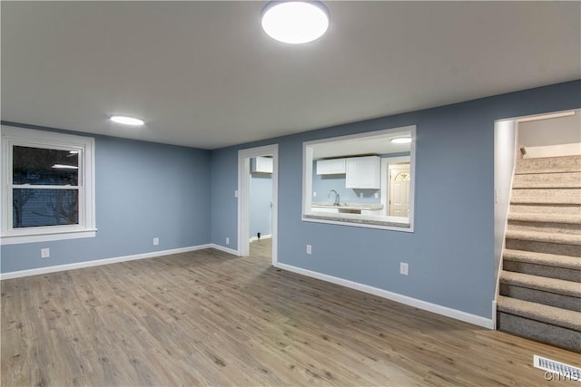 118 Leray St, Le Ray, NY 13612 - finished basement with stairs, a sink, wood finished floors, and baseboards