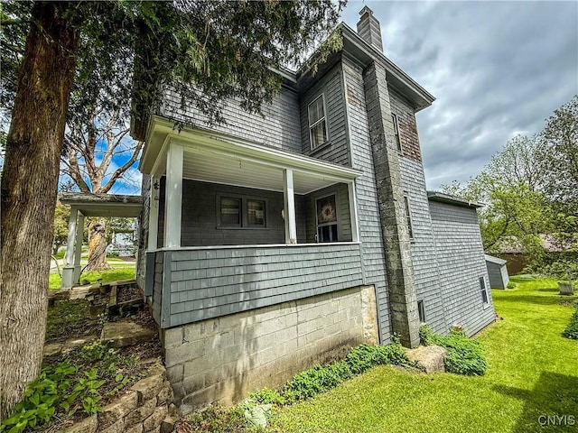 26 Farnham St, Cazenovia, NY 13035 - view of side of home with a chimney, a yard, and covered porch