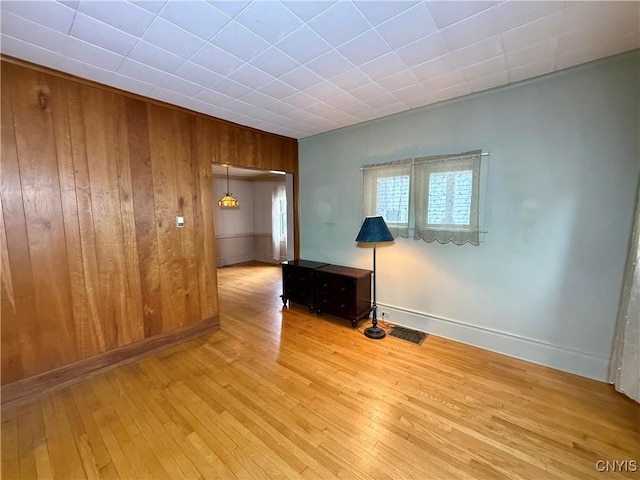 26 Farnham St, Cazenovia, NY 13035 - empty room featuring wood-type flooring, wood walls, and baseboards
