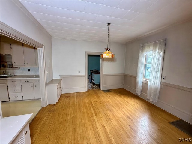26 Farnham St, Cazenovia, NY 13035 - unfurnished dining area with a sink, light wood-style floors, and ornamental molding