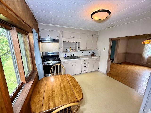 26 Farnham St, Cazenovia, NY 13035 - kitchen with stainless steel gas stove, under cabinet range hood, light countertops, a sink, and white cabinetry