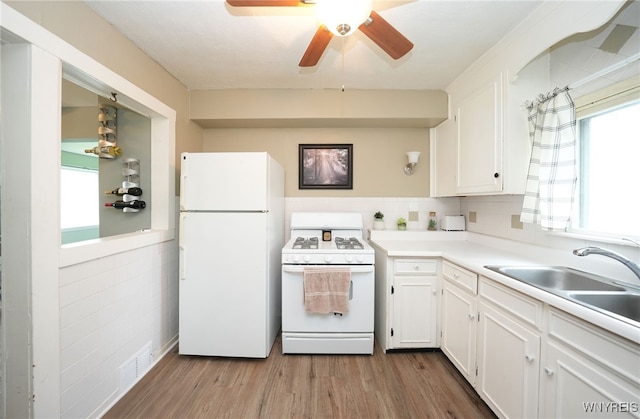 3564 Grafton Ave, Hamburg, NY 14219 - kitchen with white appliances, white cabinetry, wood finished floors, ceiling fan, and light countertops