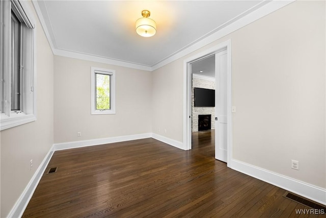 13 Ojibwa Cir, Buffalo, NY 14202 - spare room with ornamental molding, a stone fireplace, dark wood finished floors, and baseboards