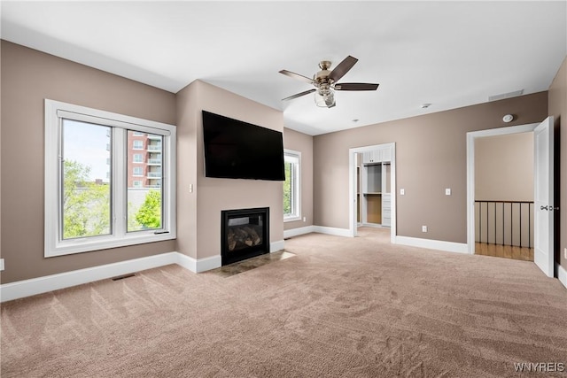 13 Ojibwa Cir, Buffalo, NY 14202 - unfurnished living room featuring light colored carpet, ceiling fan, baseboards, and a fireplace with flush hearth