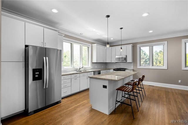 13 Ojibwa Cir, Buffalo, NY 14202 - kitchen with stainless steel appliances, a kitchen island, white cabinetry, wood finished floors, and crown molding