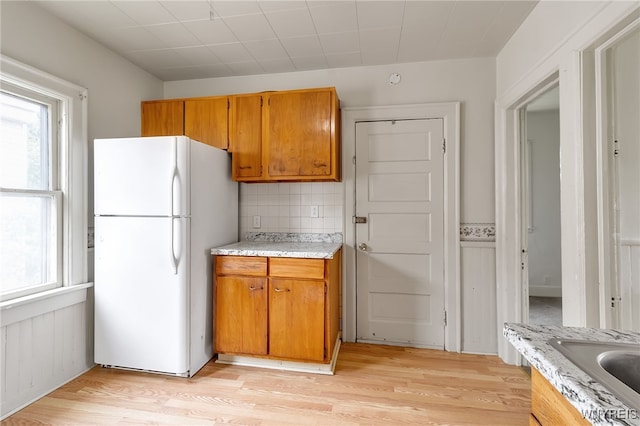 151 Edson St, West Seneca, NY 14210 - kitchen with freestanding refrigerator, light countertops, light wood-style floors, and brown cabinets
