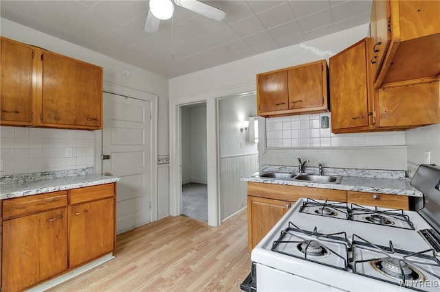 151 Edson St, West Seneca, NY 14210 - kitchen featuring a sink, light countertops, light wood-style floors, a ceiling fan, and brown cabinets