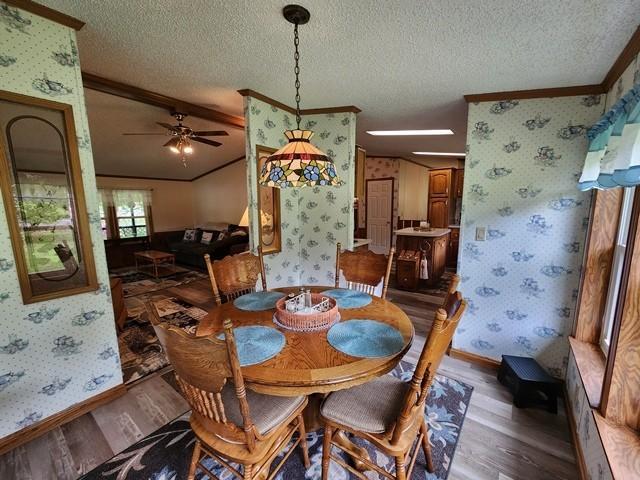3483 First Fork Rd, Grove Twp, PA 15861 - dining area with wood finished floors, wallpapered walls, crown molding, baseboards, and a textured ceiling