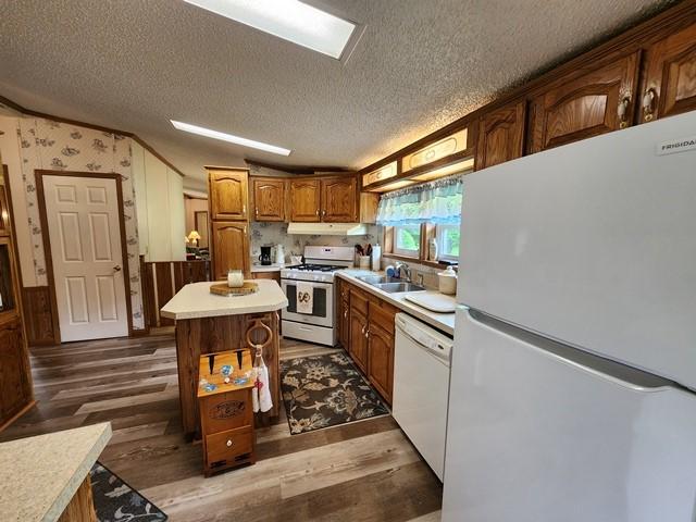 3483 First Fork Rd, Grove Twp, PA 15861 - kitchen featuring white appliances, under cabinet range hood, light countertops, dark wood-style flooring, and a sink