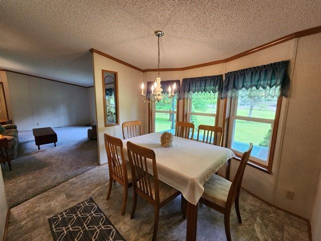 3483 First Fork Rd, Grove Twp, PA 15861 - dining room featuring crown molding, a textured ceiling, and a chandelier