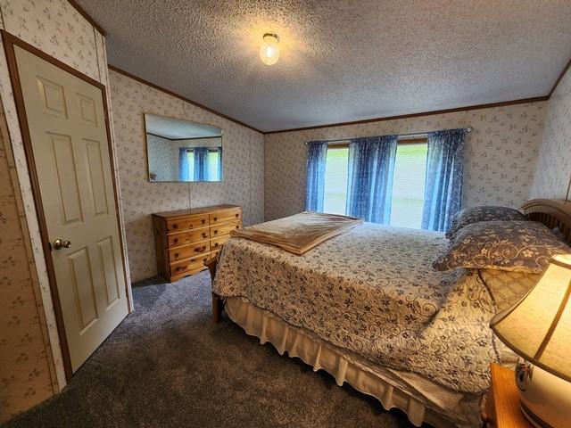 3483 First Fork Rd, Grove Twp, PA 15861 - bedroom with wallpapered walls, crown molding, dark colored carpet, a textured ceiling, and vaulted ceiling