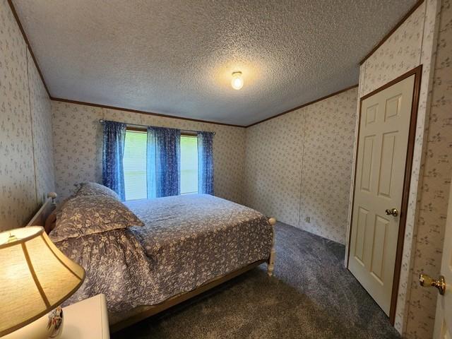 3483 First Fork Rd, Grove Twp, PA 15861 - bedroom with dark carpet, wallpapered walls, crown molding, and a textured ceiling