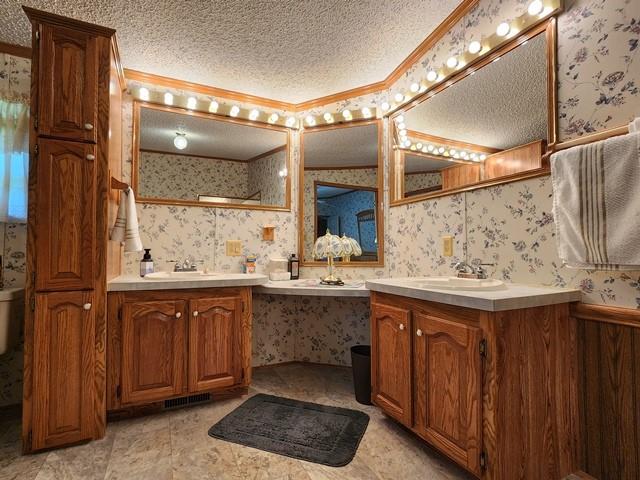 3483 First Fork Rd, Grove Twp, PA 15861 - bathroom with wallpapered walls, two vanities, and a textured ceiling
