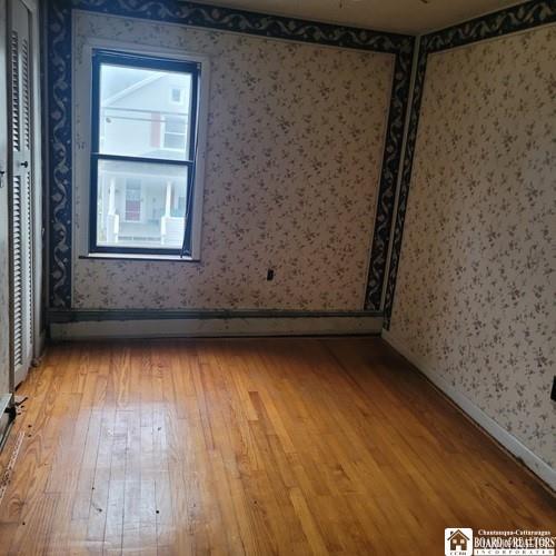 206 W Green St, Olean-City, NY 14760 - empty room with light wood-style flooring and wallpapered walls