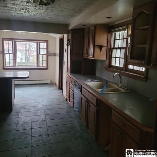 206 W Green St, Olean-City, NY 14760 - kitchen featuring dishwasher, open shelves, a sink, a baseboard radiator, and healthy amount of natural light