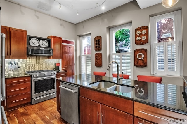 509 Virginia St, Buffalo, NY 14202 - kitchen featuring stainless steel appliances, a sink, wood finished floors, dark stone countertops, and tasteful backsplash
