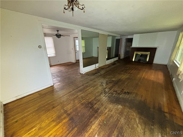 259 Fellows Ave, Syracuse, NY 13210 - unfurnished living room with hardwood / wood-style flooring, a fireplace, a ceiling fan, and baseboards
