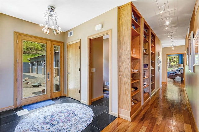 8763 Greyton H Taylor Memorial Dr, Urbana, NY 14840 - entrance foyer with rail lighting, a chandelier, healthy amount of natural light, and baseboards