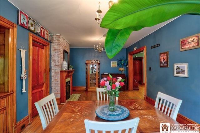 25 Academy St, Westfield, NY 14787 - dining space featuring a chandelier, wood finished floors, baseboards, and a brick fireplace