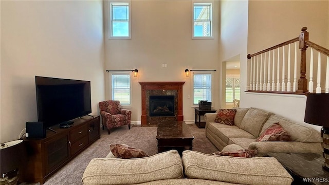 65 Islewoods, Grand Island, NY 14072 - living room featuring a towering ceiling, light colored carpet, a fireplace, and baseboards