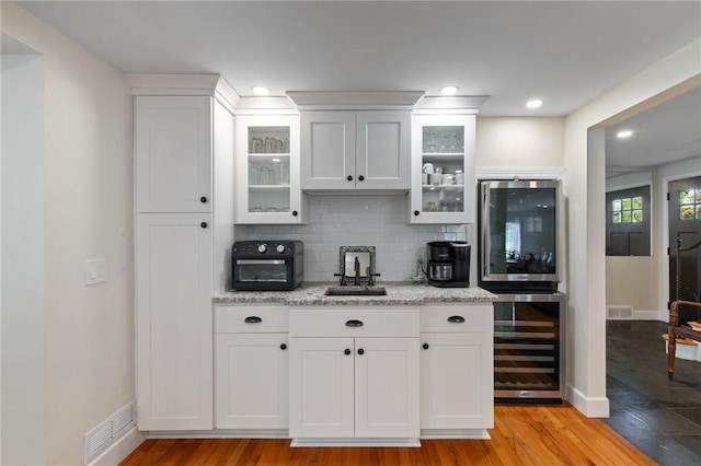 1 Creekside Ln, Pittsford, NY 14618 - kitchen featuring beverage cooler, a sink, decorative backsplash, white cabinets, and recessed lighting