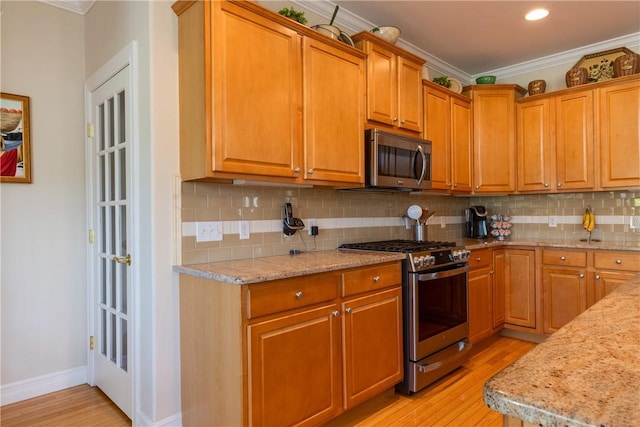 31 Hunters Run, Horseheads, NY 14845 - kitchen with appliances with stainless steel finishes, ornamental molding, light wood-style flooring, tasteful backsplash, and light stone countertops