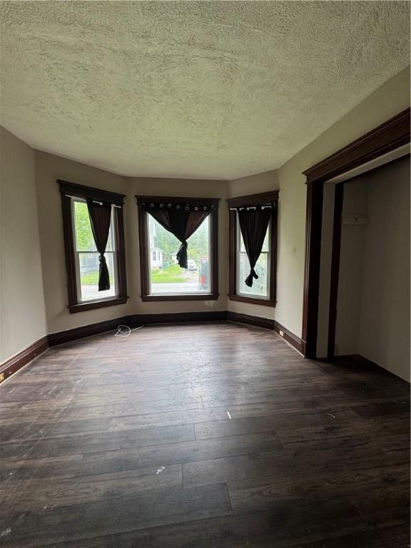 127 Maryland St, Rochester, NY 14613 - empty room with dark wood-style floors, a textured ceiling, and baseboards